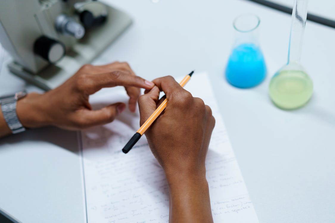 Person Writing on White Paper