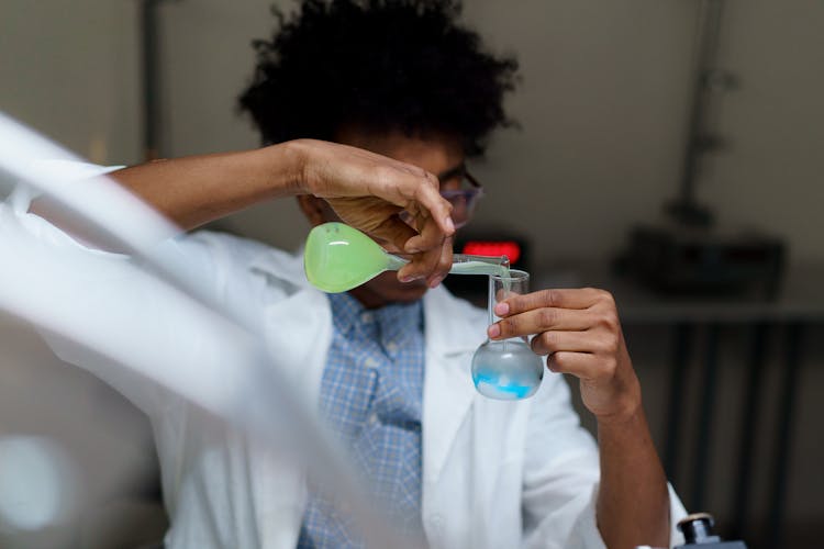 Man Mixing  Chemicals In A Flask