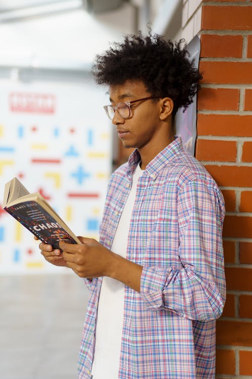 Homem De Camisa Xadrez Vermelha Branca E Azul Segurando Um Livro