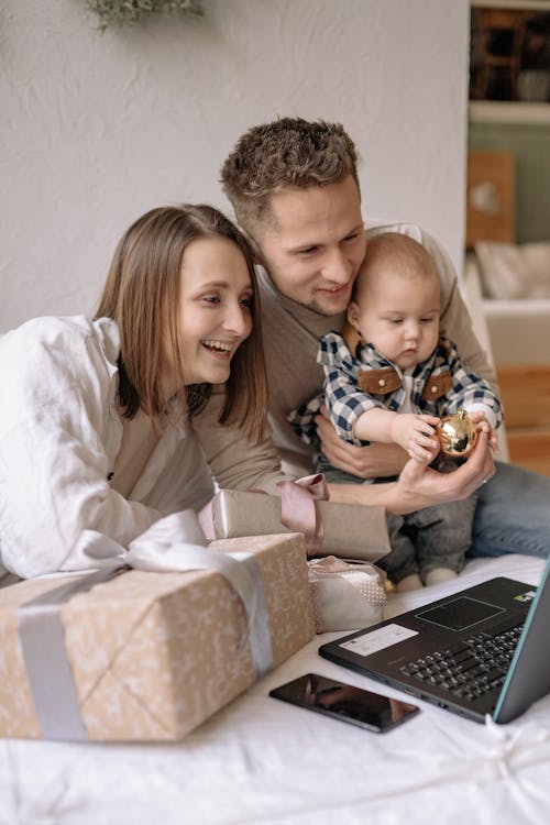 Free Couple Sitting with Their Son while Having a Video Call on Laptop Stock Photo