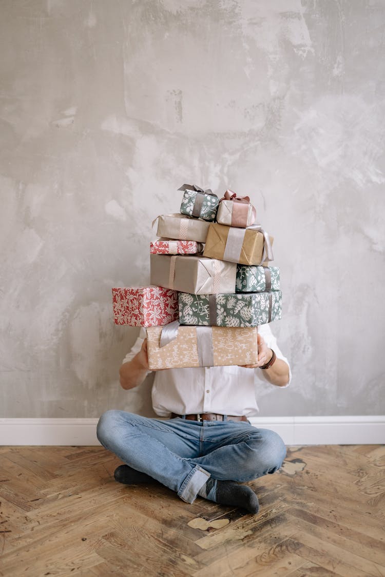 Person Sitting On Floor While Carrying Gifts