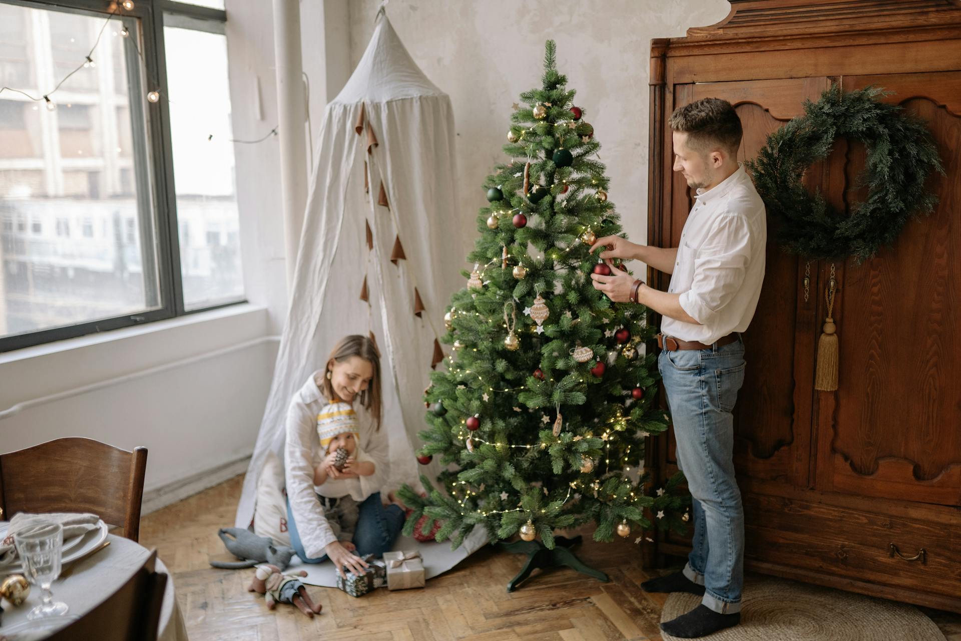 Family Putting Christmas Balls on a Tree