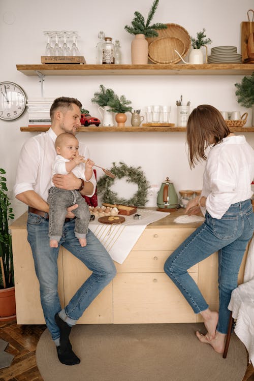 Free Young Couple with a Baby Preparing a Meal  Stock Photo