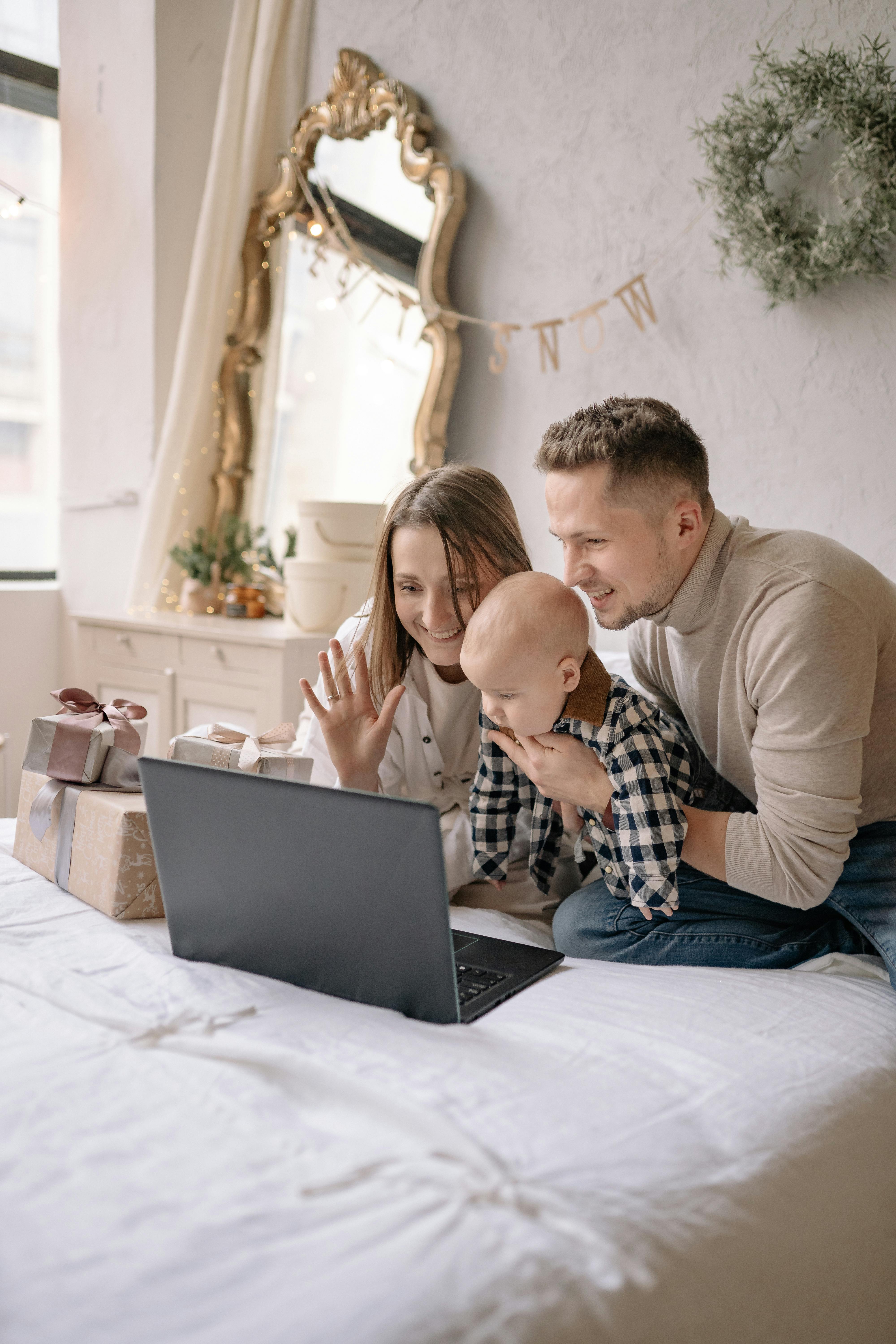 a family in a bed with a laptop