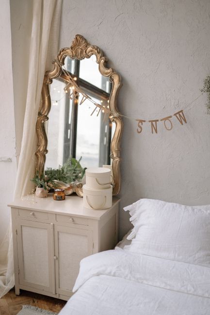 A cozy bedroom featuring a vintage mirror and stylish decor elements.