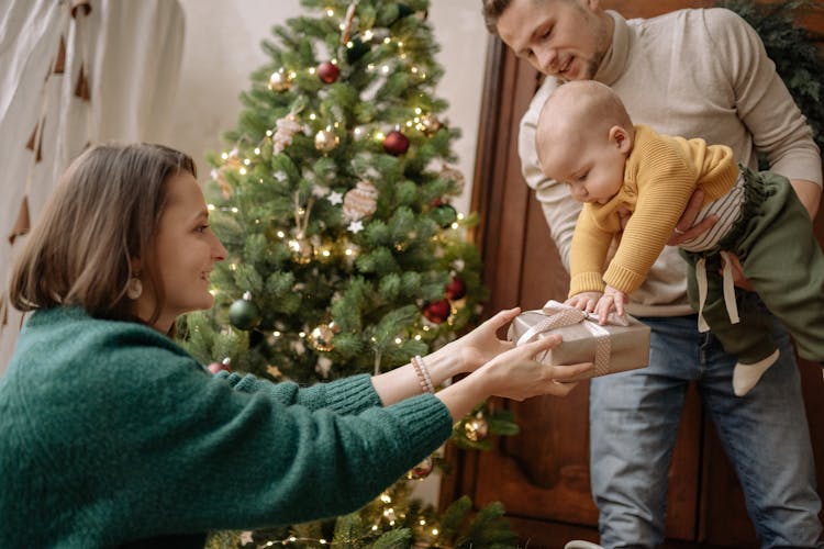 Man And Woman With A Baby Receiving Christmas Gift