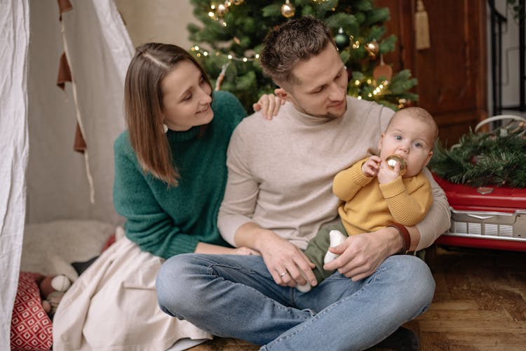 Happy Parents With Toddler At Home On Winter Holidays