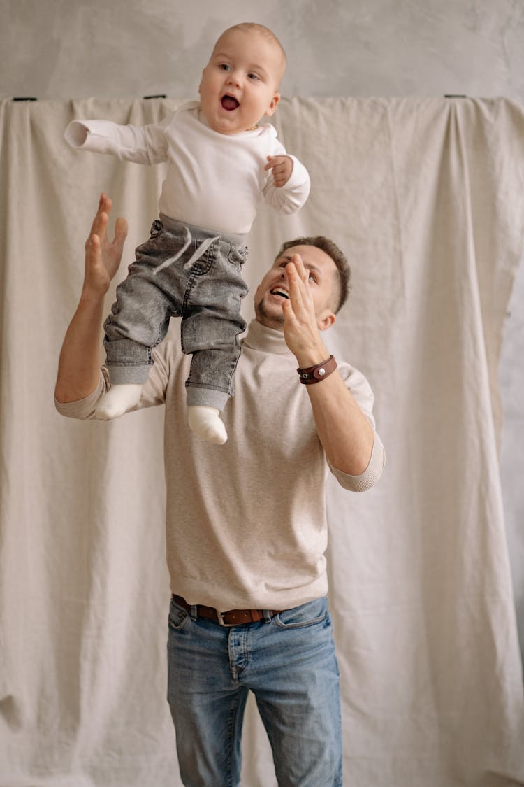 A Father Tossing His Baby On Air