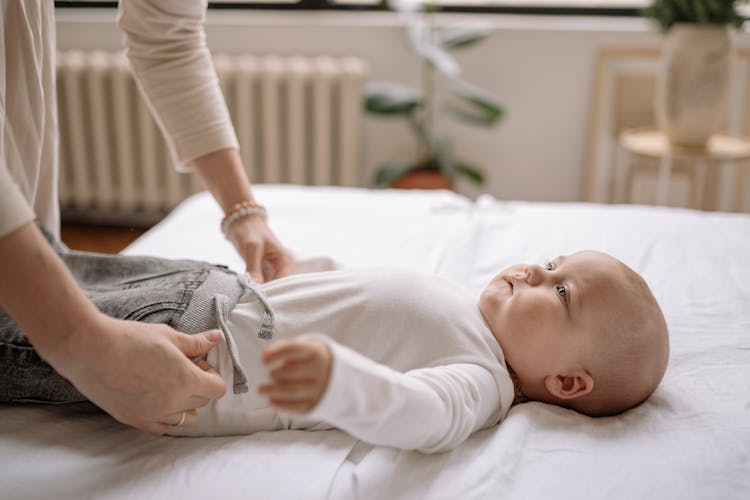 Woman Dressing A Baby 