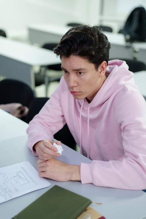 Man In Roze Hoodie Schrijven Op Wit Papier