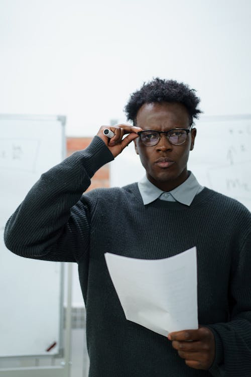 Young elegant Man in Eyeglasses Holding a Piece of Paper 