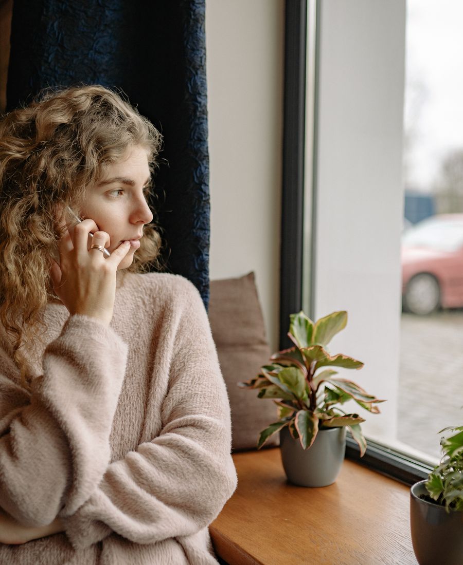 A person talking on the phone by a window