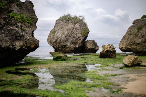 Free Explore a dramatic coastal scene featuring large rock formations and tidal pools on a cloudy day. Stock Photo