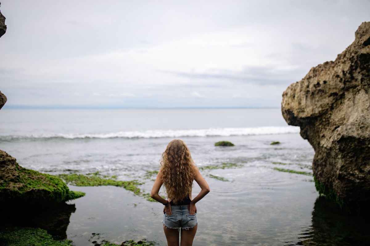 A woman by the sea in denim shorts — how to wear denim shorts the Riviera way