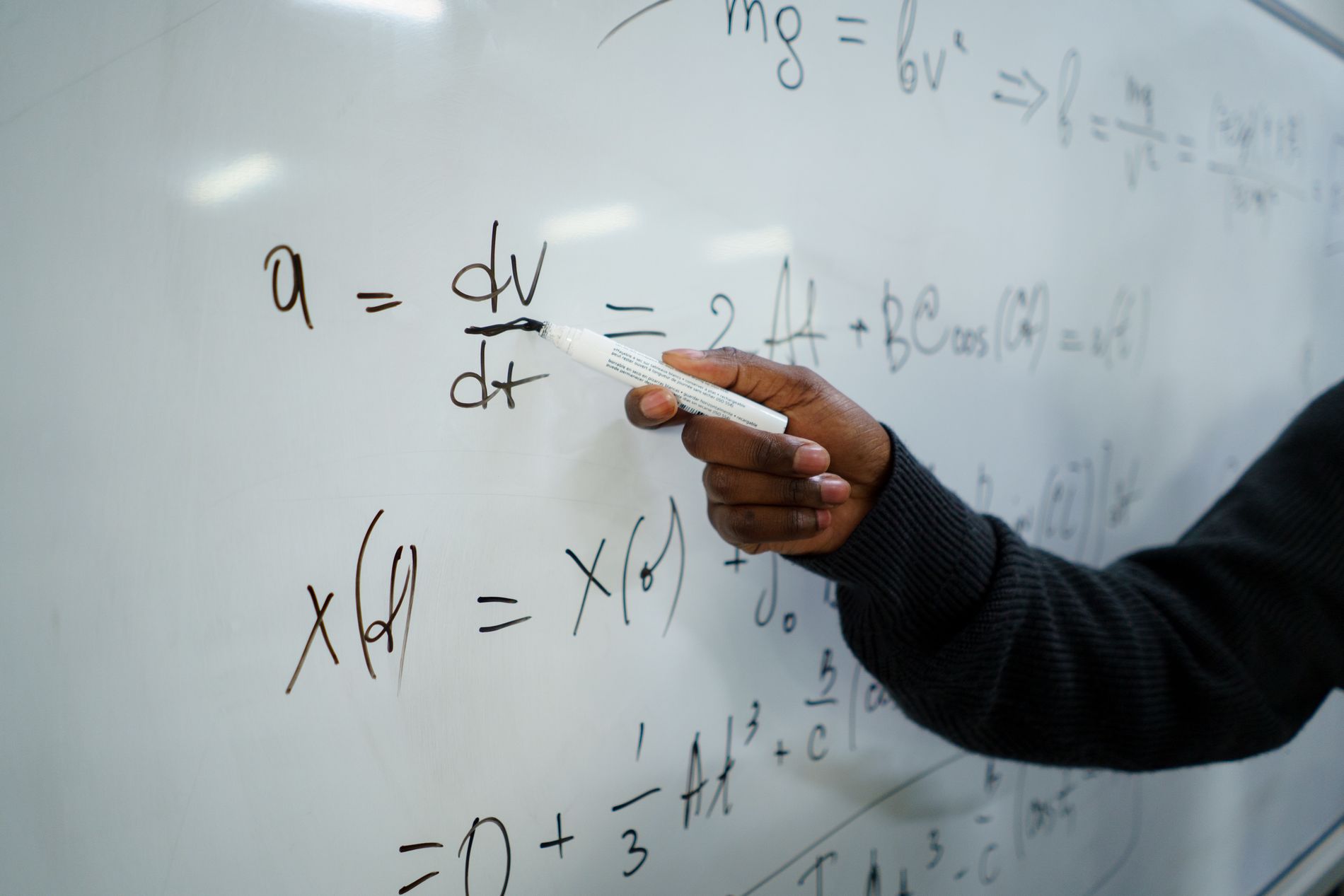 Writing equations on a whiteboard in a classroom