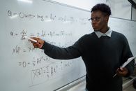 Man in Black Sweater Writing on Whiteboard