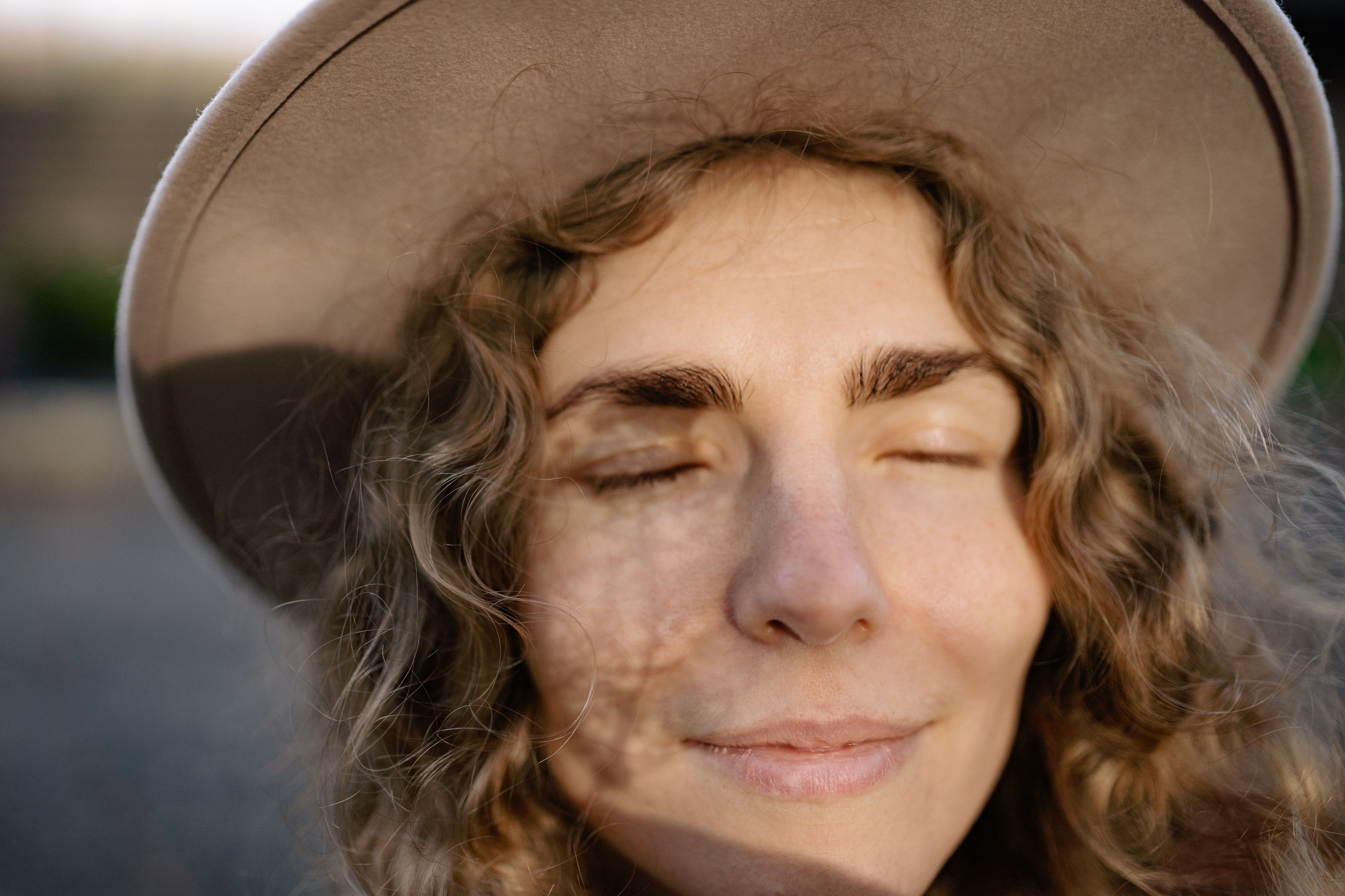 woman applying cool moisturizer to a red sunburned face in a bathroom