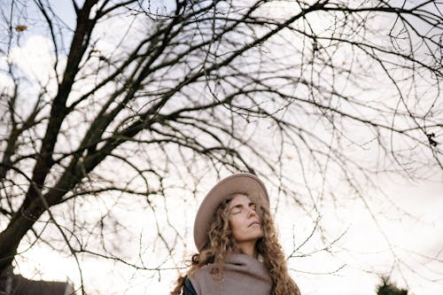 A Woman with Curly Hair Wearing a Hat