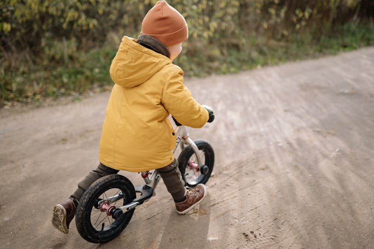 Back View Of A Child Riding A Bike