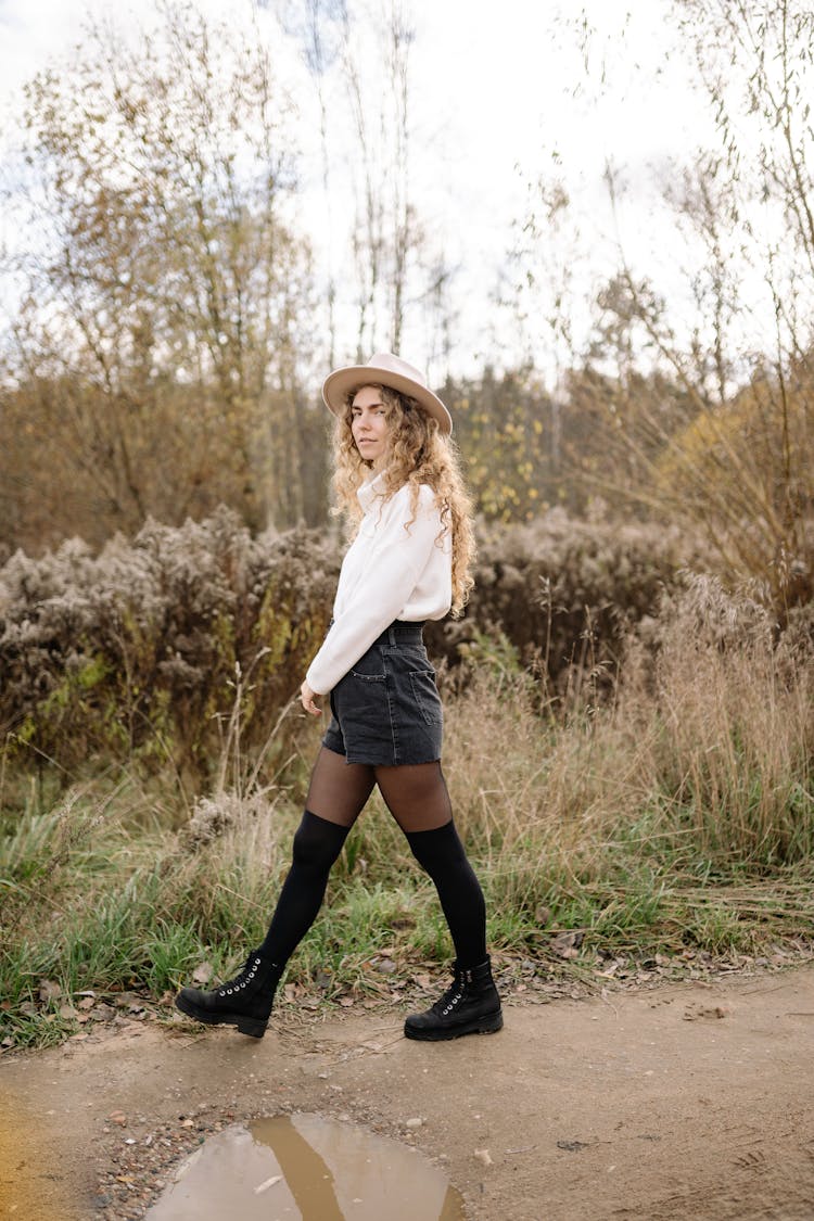 Woman Wearing Knee Socks, Shorts And Hat Walking In Nature 