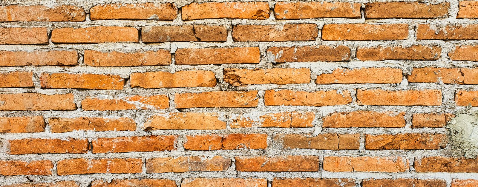 Close-up of an orange brick wall showcasing texture and pattern, ideal for backgrounds.