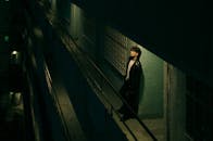 Man Standing on a Balcony of a Residential Building at Night