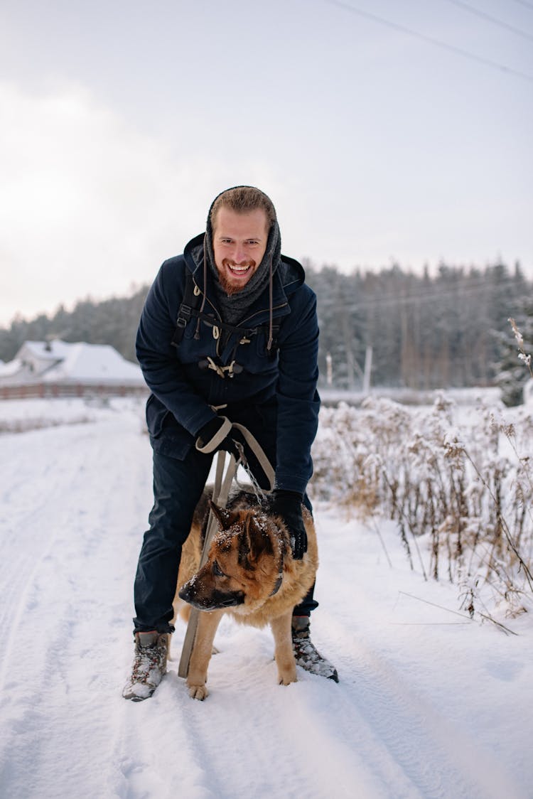 Smiling Man With A Dog On A Walk In Winter And Forest In Background