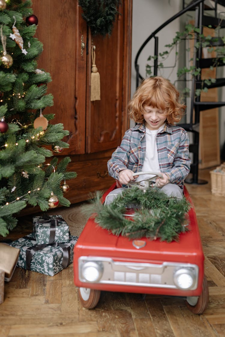 Boy Driving A Toy Car At Christmas 