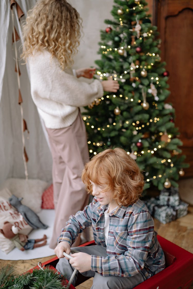 Mother And Daughter Decorating Christmas Tree