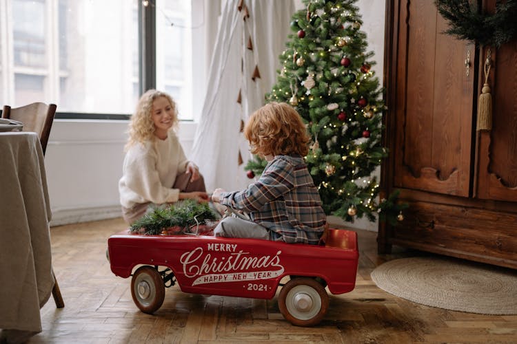 A Boy Riding In A Toy Car On Christmas