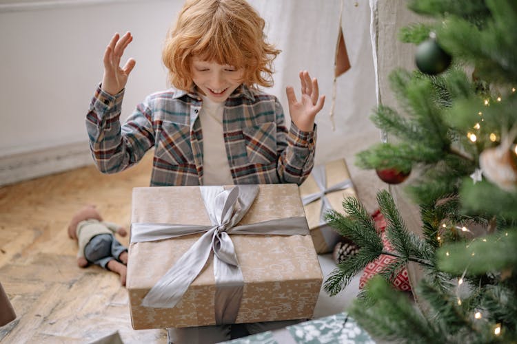 A Happy Boy Looking At His Christmas Present