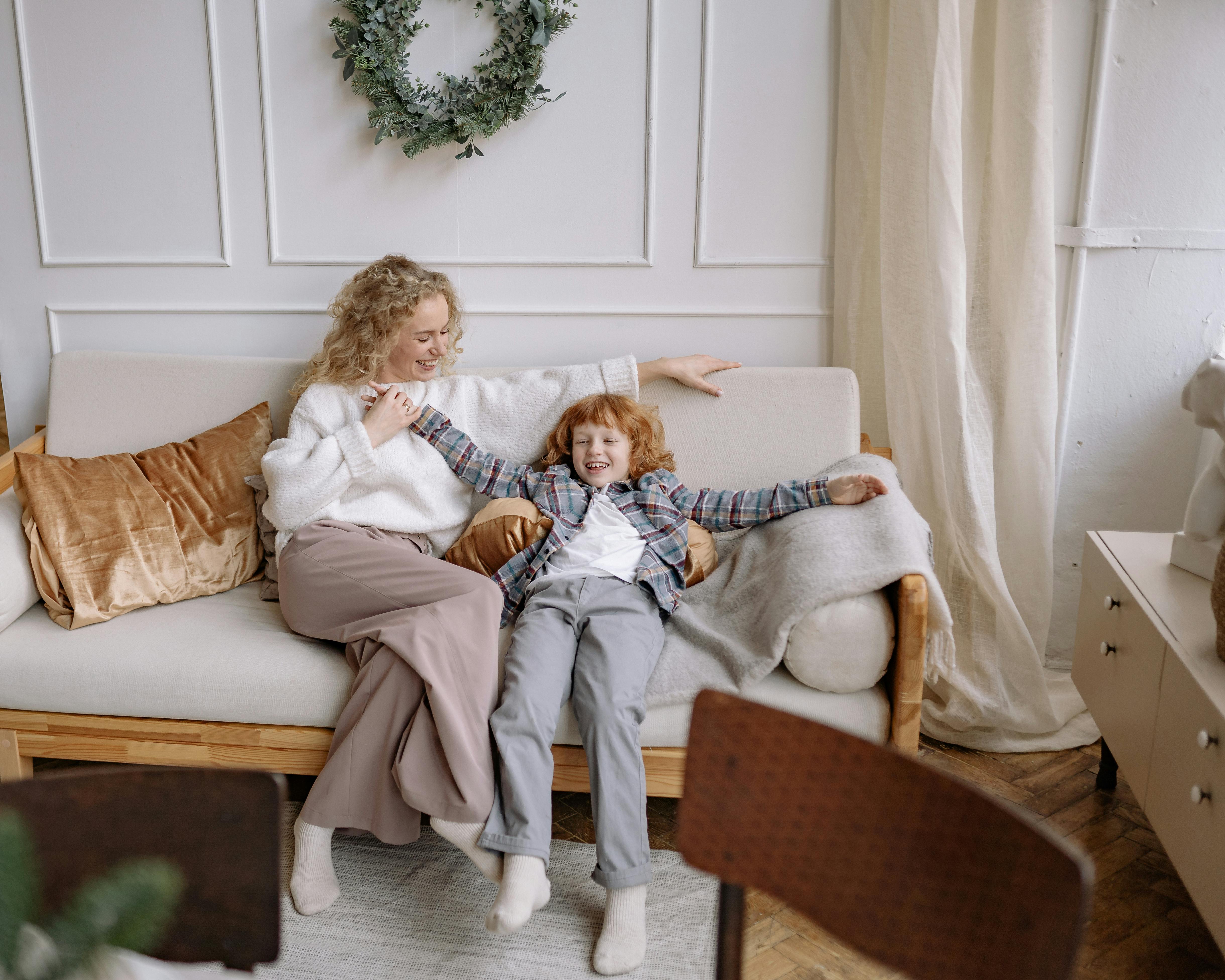 a woman sitting on a couch with her son