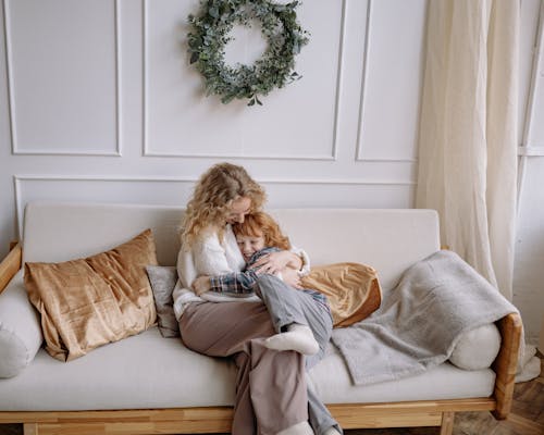 Free A Woman Hugging her Son on a Couch Stock Photo