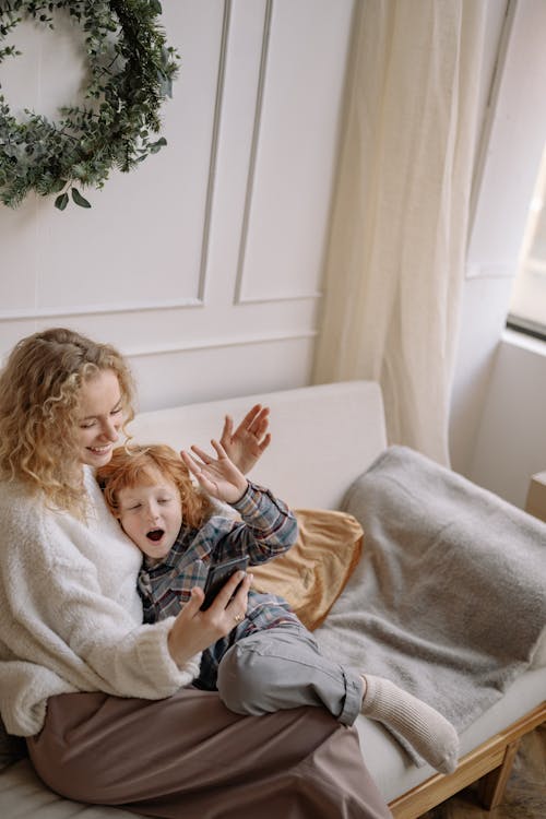 Free A Woman Sitting on a Couch with her Son Stock Photo