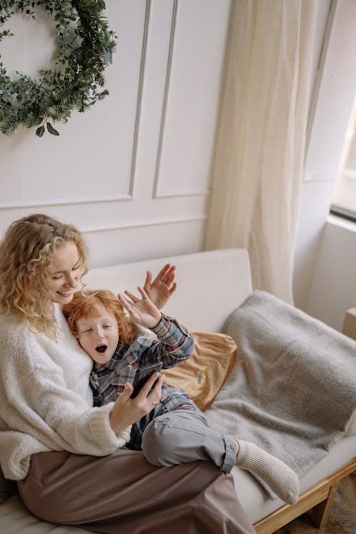 A Woman Sitting on a Couch with her Son