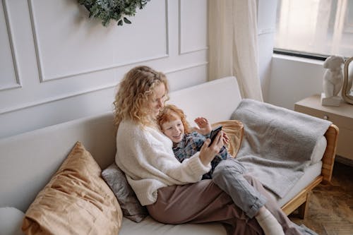 A Woman Taking a Selfie on a Couch with her Son