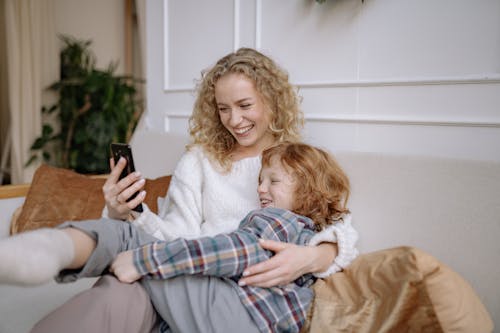 Free A Woman Taking a Selfie on a Couch with her Son Stock Photo