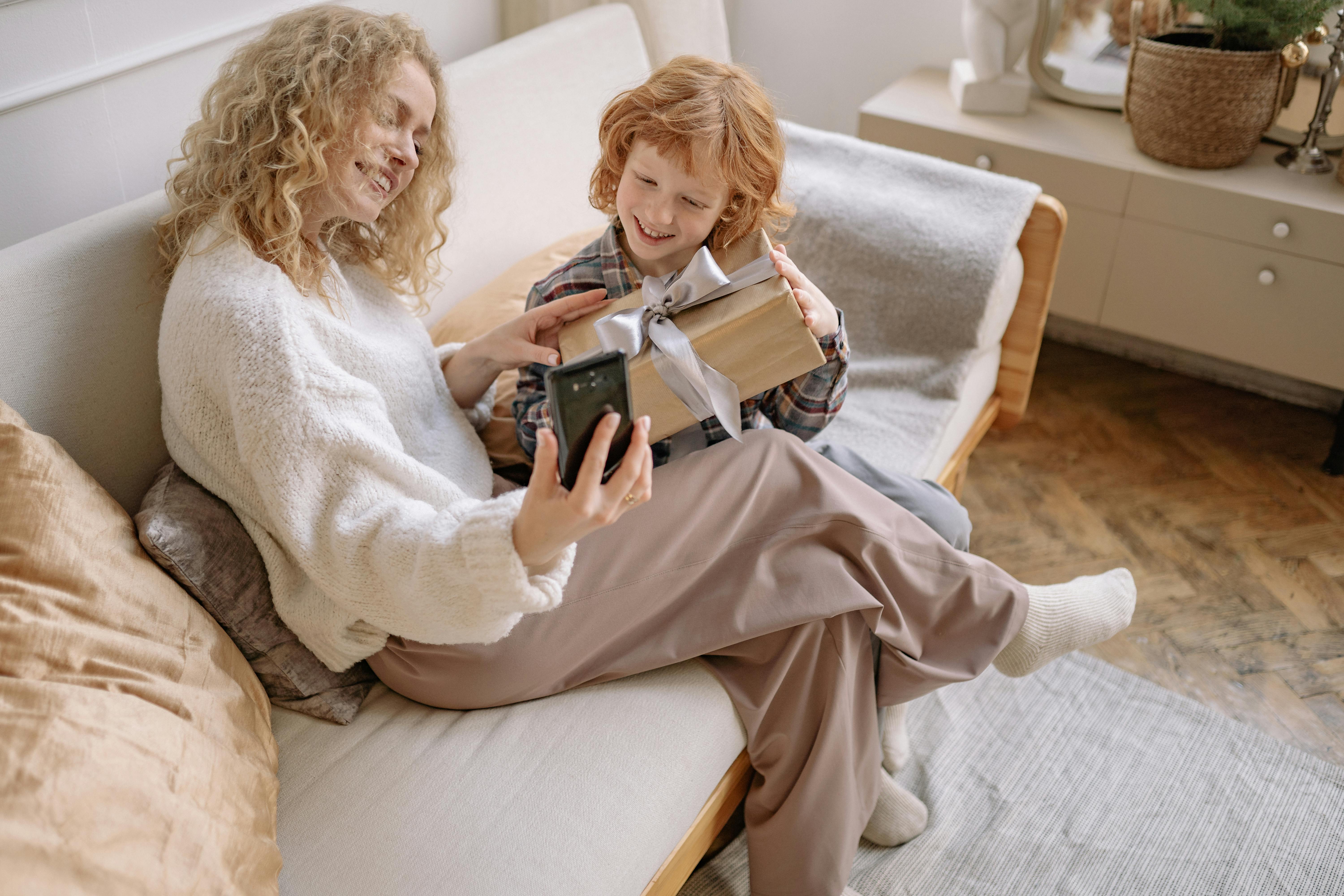 A Woman Taking a Selfie on a Couch with her Son · Free Stock Photo