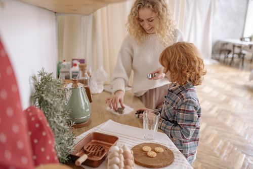 Free A happy mother and child bonding while baking together in a warm kitchen setting. Stock Photo