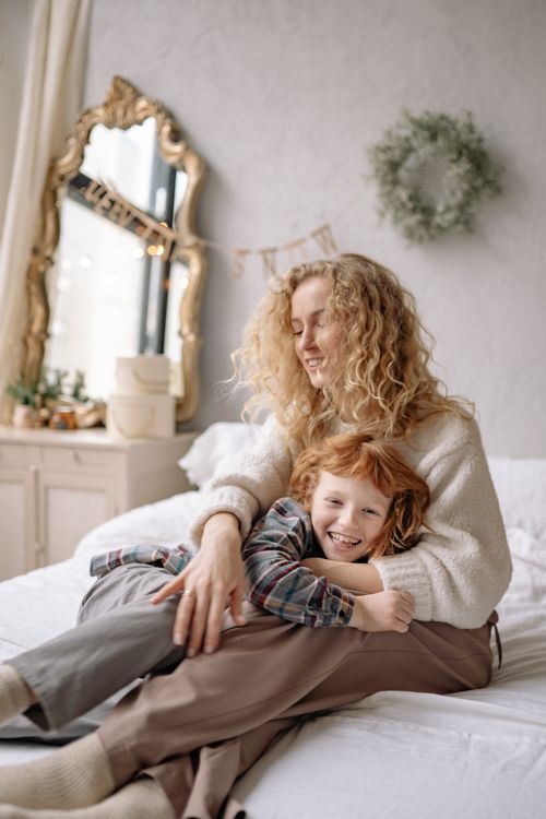 Free Loving moment between mother and son in a cozy bedroom, emphasizing family bonding and warmth. Stock Photo