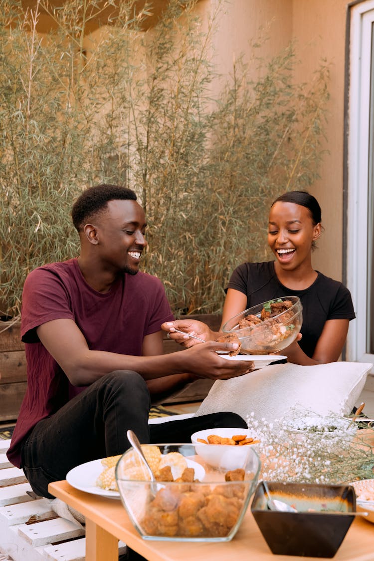 Young Man And Woman Sitting At The Table And Eating 