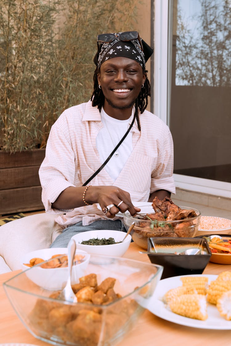 Smiling Man Eating At Table Outside