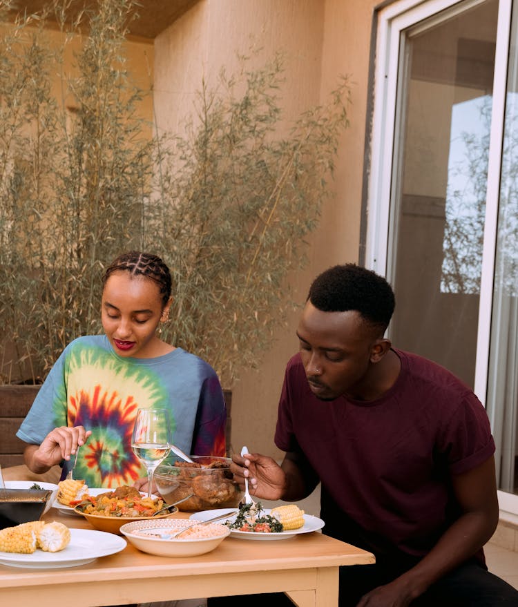 Man And Woman Sitting And Eating Dinner 