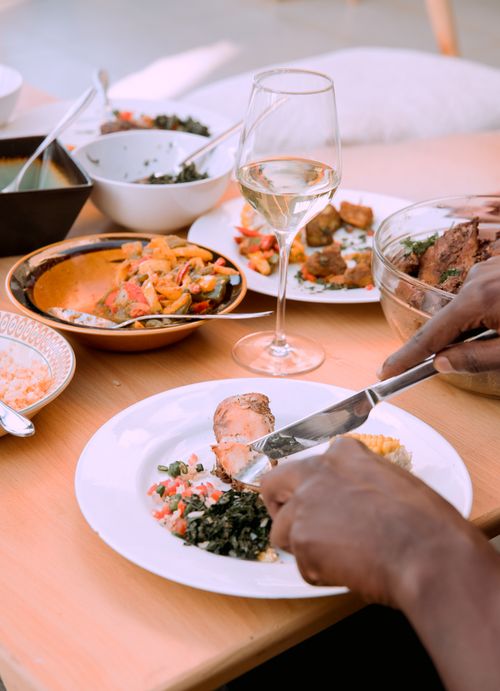 Free A person enjoying a delicious dinner with diverse dishes and a glass of wine. Stock Photo
