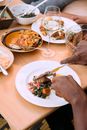 Person Holding Stainless Steel Fork and Knife on White Ceramic Plate