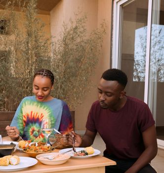 Young couple enjoying a meal together outdoors, showcasing vibrant flavors and companionship.