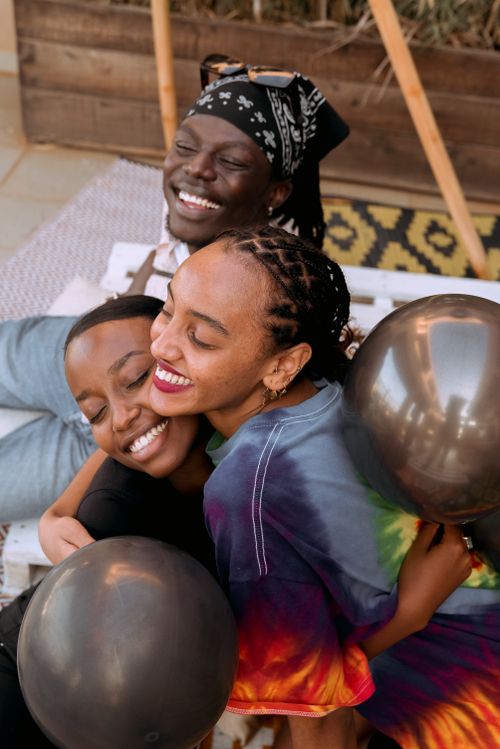 Free A happy family embracing and celebrating with balloons in a cozy indoor setting. Stock Photo