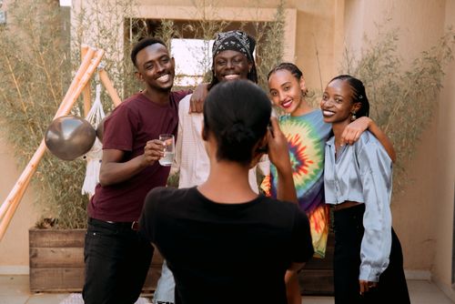Free Group of friends smiling and posing for a picture outdoors, capturing joyful moments together. Stock Photo