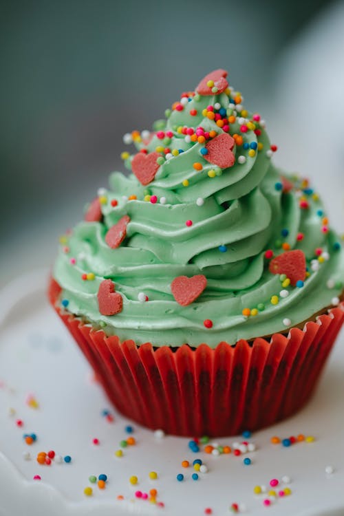 Free Closeup from above of appetizing sweet cupcake decorated green whipped cream and multicolored sprinkles Stock Photo