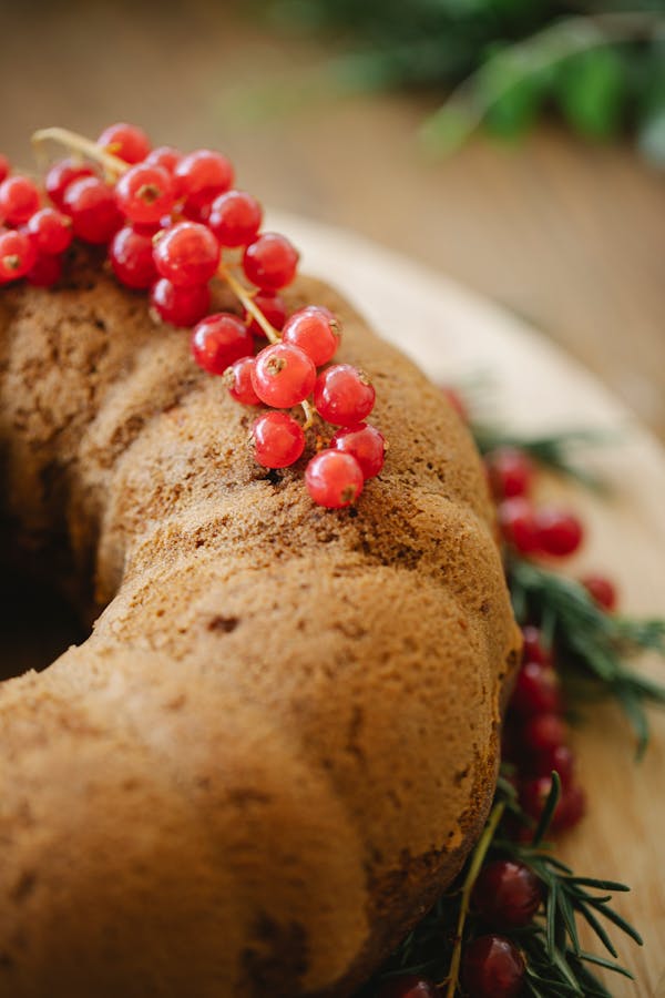 Traditional Christmas cake with green sprigs of rosemary and red berries